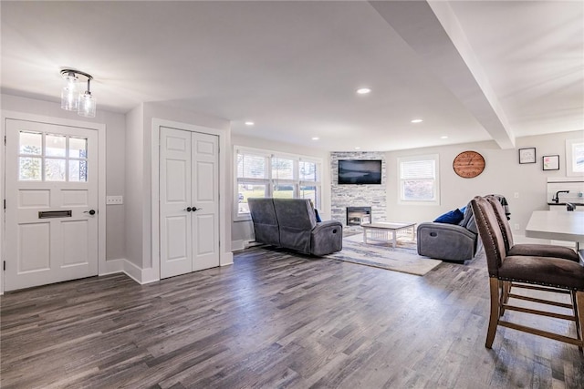 living area featuring beamed ceiling, recessed lighting, a fireplace, and dark wood-type flooring