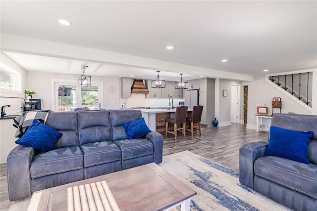 living area with stairs, recessed lighting, baseboards, and light wood finished floors