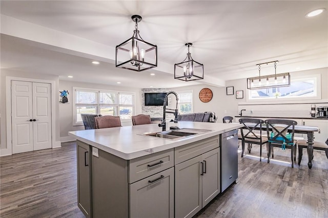 kitchen with dark wood-style floors, gray cabinets, dishwasher, and a sink