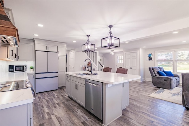 kitchen featuring open floor plan, light countertops, a wealth of natural light, stainless steel appliances, and a sink