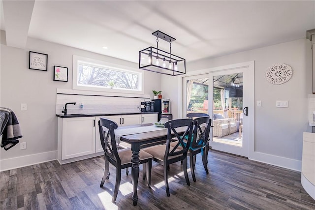 dining space with a wealth of natural light, dark wood-type flooring, and baseboards