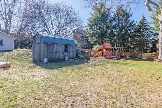 view of yard with fence private yard, a storage shed, an outdoor structure, and a playground