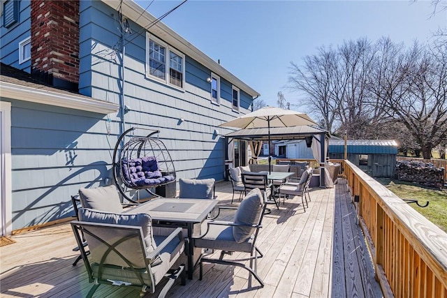 deck featuring a gazebo and outdoor dining space