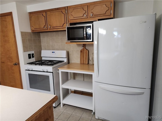 kitchen with decorative backsplash, white appliances, and brown cabinetry