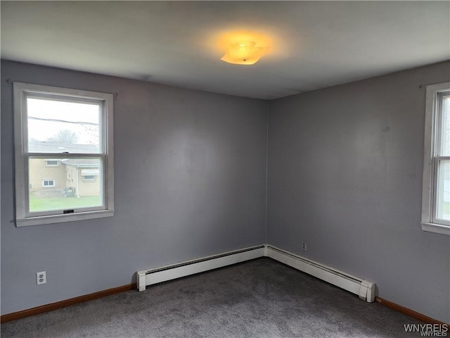 empty room featuring baseboards, dark carpet, and a baseboard radiator