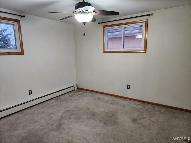 spare room with a baseboard heating unit, carpet, baseboards, and ceiling fan