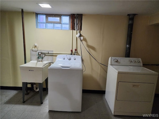 laundry room featuring baseboards, separate washer and dryer, and laundry area