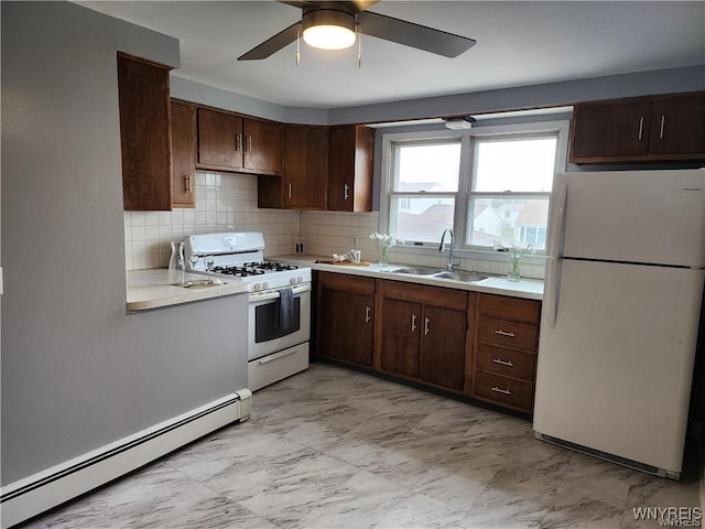 kitchen with white appliances, a sink, light countertops, a baseboard heating unit, and marble finish floor