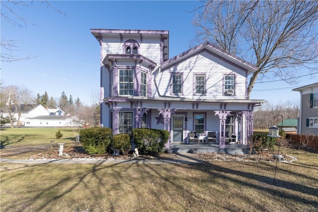 italianate-style house featuring a porch and a front lawn