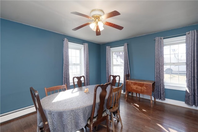 dining space with a wealth of natural light, baseboard heating, and wood finished floors