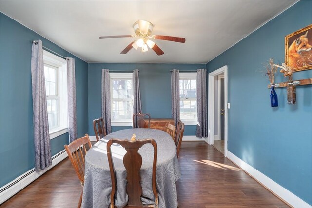 dining space with wood finished floors, baseboards, baseboard heating, and ceiling fan