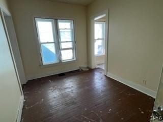 spare room with dark wood-style floors and baseboards