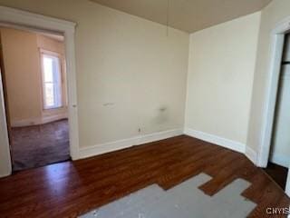 empty room featuring wood finished floors and baseboards