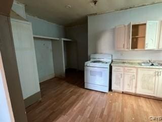 kitchen featuring a sink, light countertops, light wood-type flooring, and white gas range oven