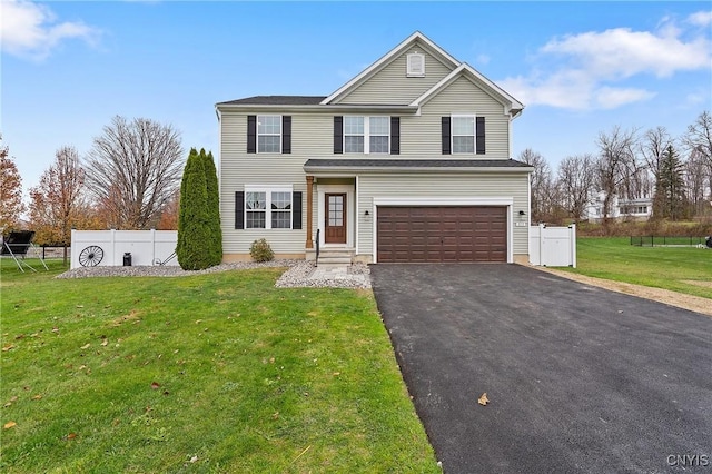 traditional home with a front lawn, fence, a garage, and driveway