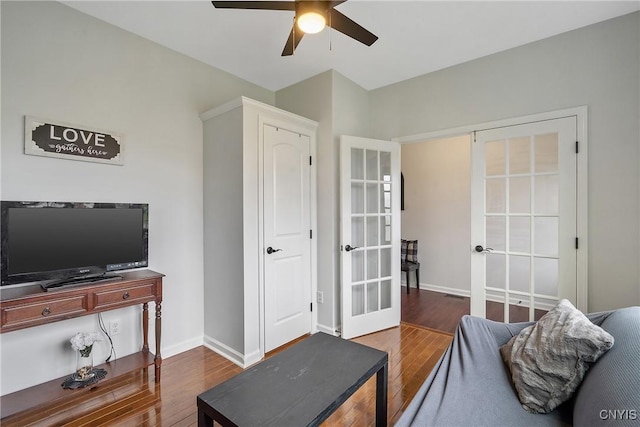 living area with ceiling fan, french doors, baseboards, and wood finished floors