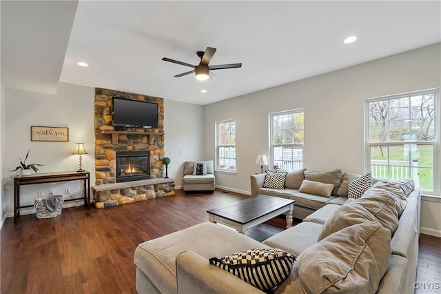 living room with recessed lighting, baseboards, a stone fireplace, and wood finished floors