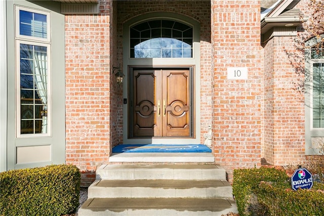 doorway to property with brick siding