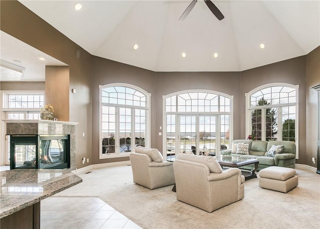 living area with plenty of natural light, light carpet, high vaulted ceiling, and a fireplace