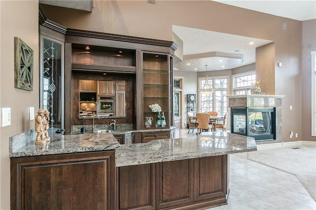 bar featuring baseboards, recessed lighting, a fireplace, a sink, and light carpet