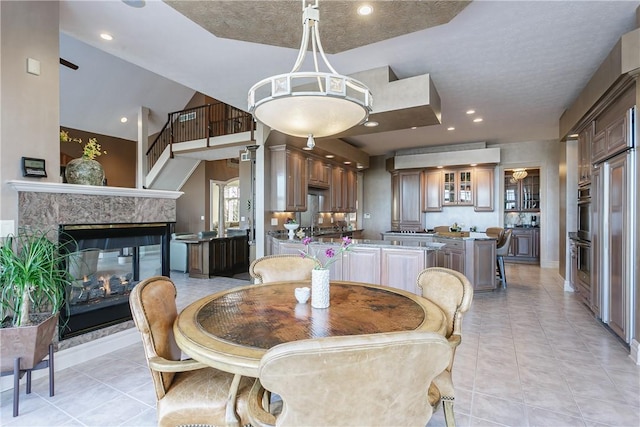 dining space featuring light tile patterned floors, recessed lighting, a multi sided fireplace, and baseboards