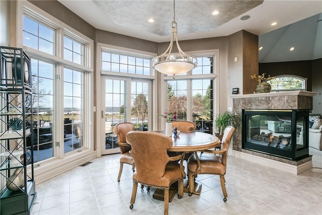 dining area featuring visible vents, light tile patterned floors, recessed lighting, a fireplace, and a textured ceiling