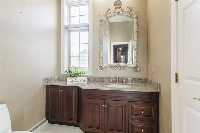 half bath featuring vanity, tile patterned floors, and toilet