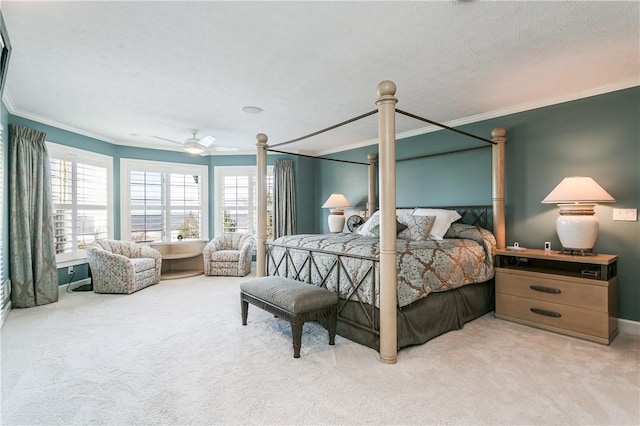 carpeted bedroom with ceiling fan and ornamental molding