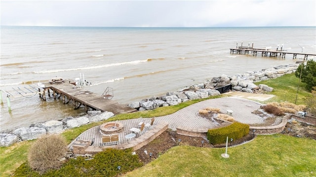 dock area featuring a patio, a fire pit, and a water view