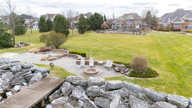 view of yard featuring a residential view, a fire pit, and a patio