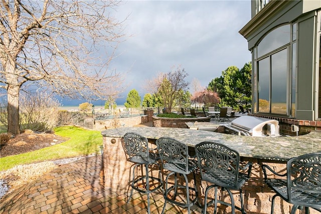 view of patio with outdoor wet bar, a grill, and exterior kitchen