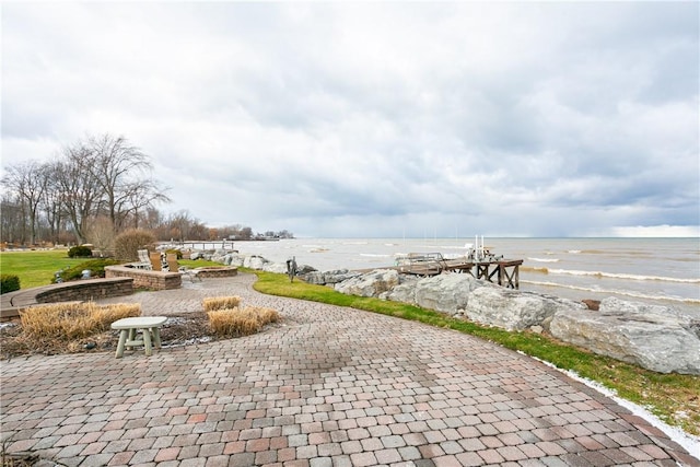 surrounding community featuring a patio and a water view