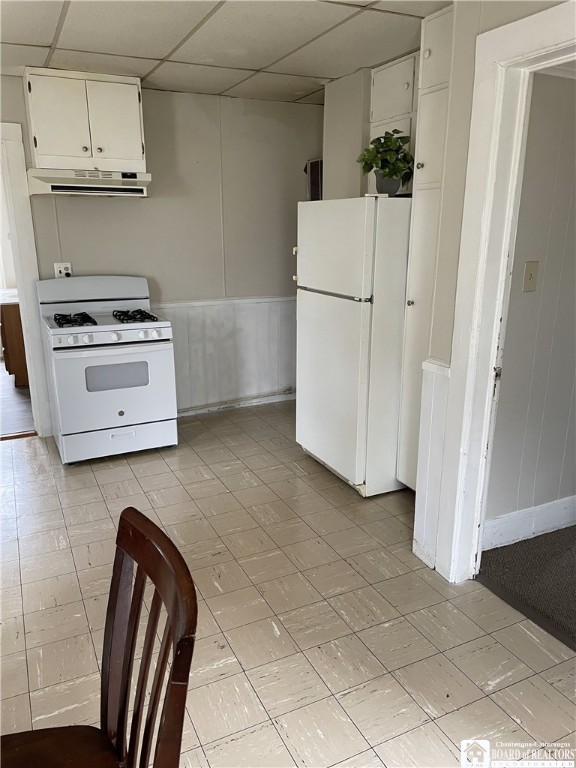 14 Moore Ave, Pomfret, NY 14063 - kitchen featuring white appliances, a paneled ceiling, a wainscoted wall, white cabinetry, and range hood