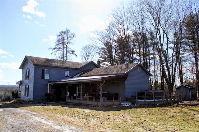 back of property featuring an outbuilding, a shed, and a yard