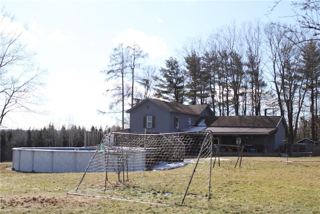 rear view of house featuring a lawn and an outdoor pool