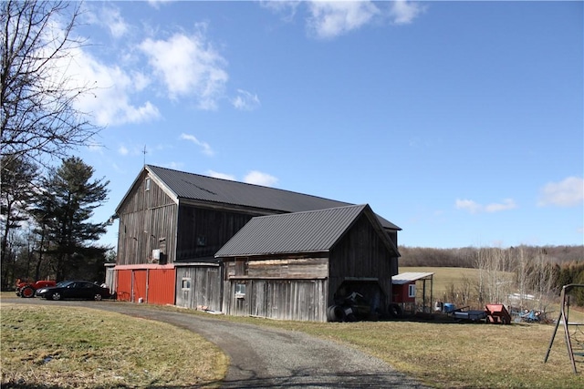 view of barn with a lawn and driveway