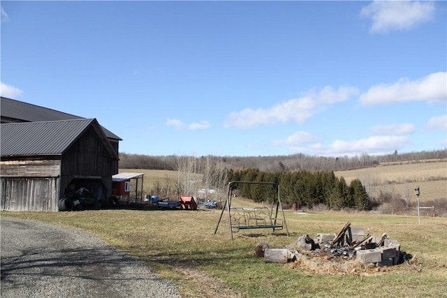 view of yard with an outbuilding, a rural view, and a barn