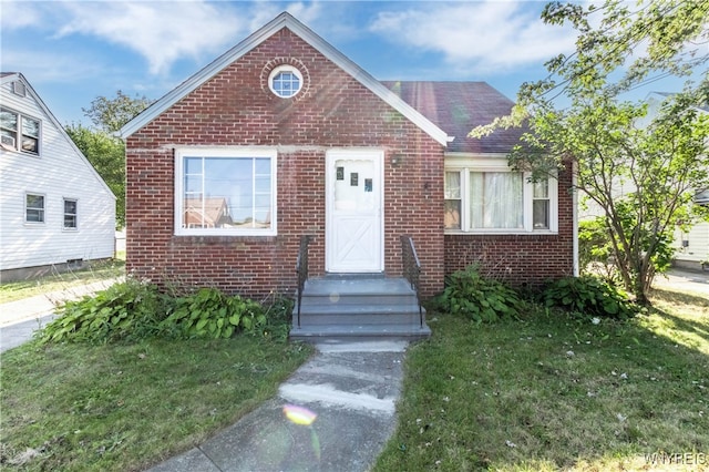 bungalow-style home featuring a front yard and brick siding