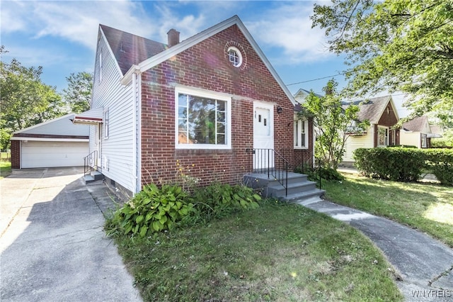 view of front of home with an outdoor structure, a front yard, brick siding, and a detached garage