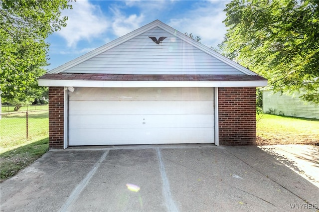 detached garage featuring fence