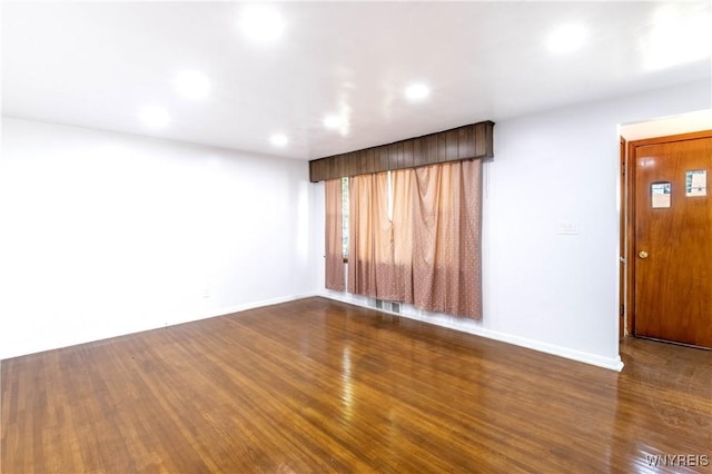 empty room featuring visible vents, recessed lighting, baseboards, and wood finished floors