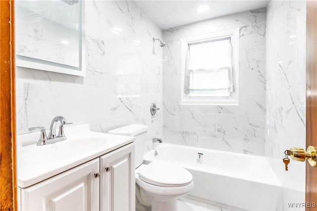 bathroom with tile walls, toilet,  shower combination, and vanity