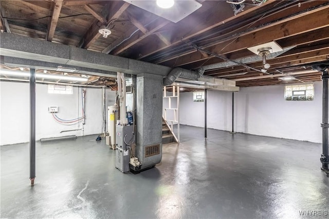 below grade area featuring heating unit, gas water heater, and stairs