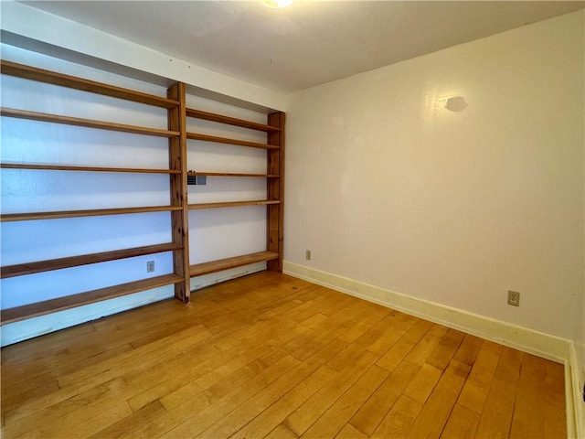 unfurnished room with baseboards and light wood-type flooring