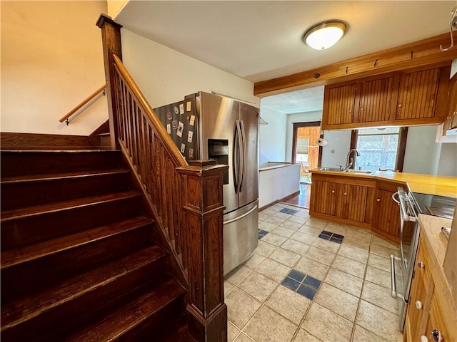 kitchen featuring visible vents, light countertops, brown cabinets, appliances with stainless steel finishes, and a sink