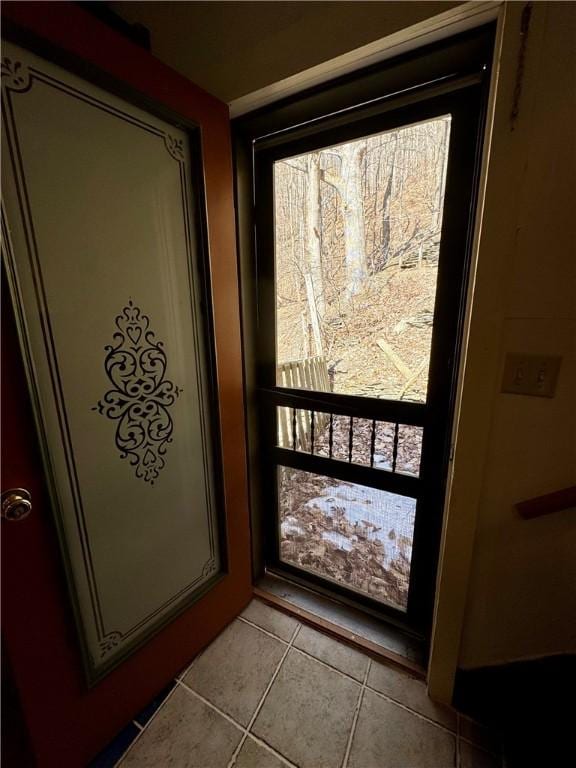 doorway to outside with tile patterned flooring