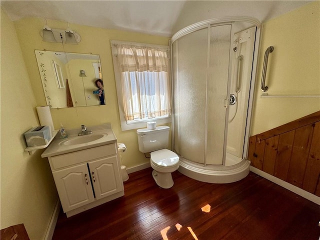 full bathroom featuring vanity, wood finished floors, baseboards, a shower stall, and toilet