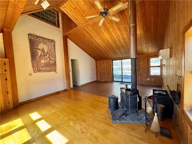 living room featuring wood finished floors, visible vents, high vaulted ceiling, a wood stove, and wooden ceiling