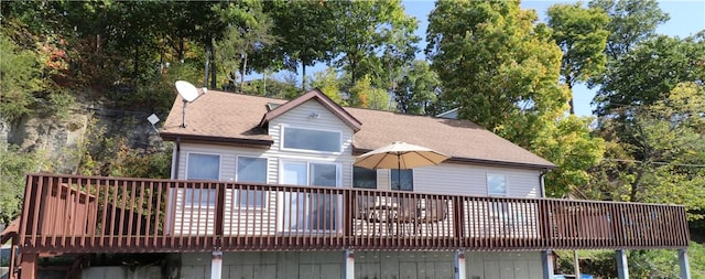 view of front facade with a wooden deck and roof with shingles