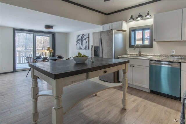 kitchen featuring dishwashing machine, light wood-style flooring, stainless steel refrigerator with ice dispenser, white cabinetry, and a sink